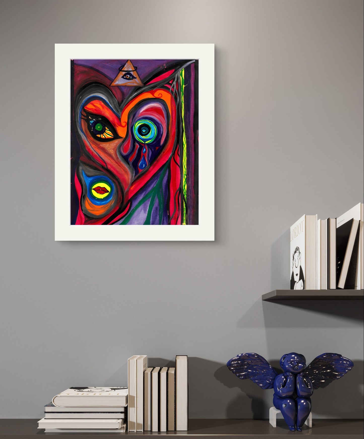 Bordered version of woman face art on grey wall above books and blue angel.