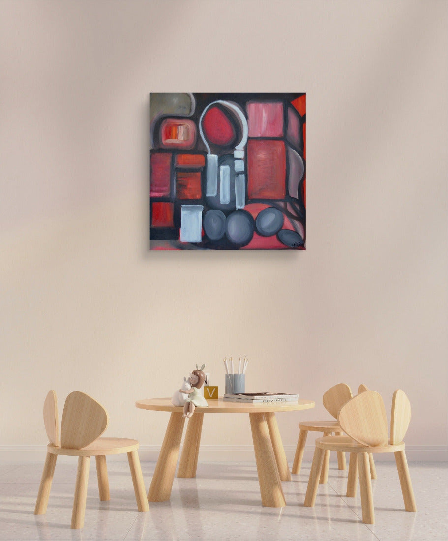Red shapes painting on white wall over wooden table and chairs.