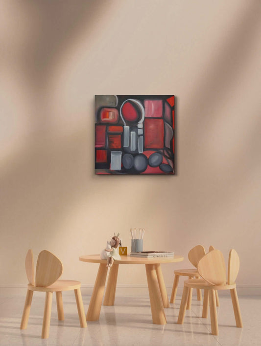 Red shapes painting on white wall above wooden table and chairs.