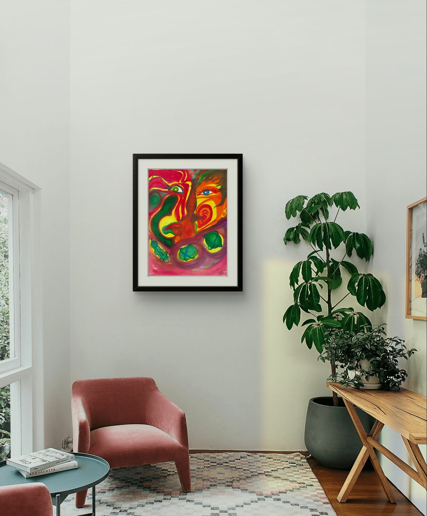 Black framed painting on white wall above red chair and plant.