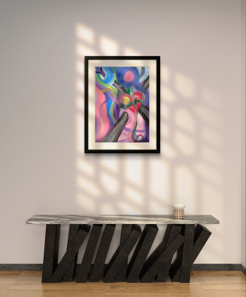 Framed heart tethered print on white wall above slanted black counter.