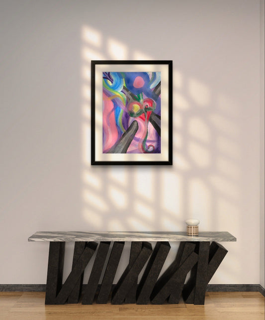 Framed heart tethered print on white wall above slanted black counter.