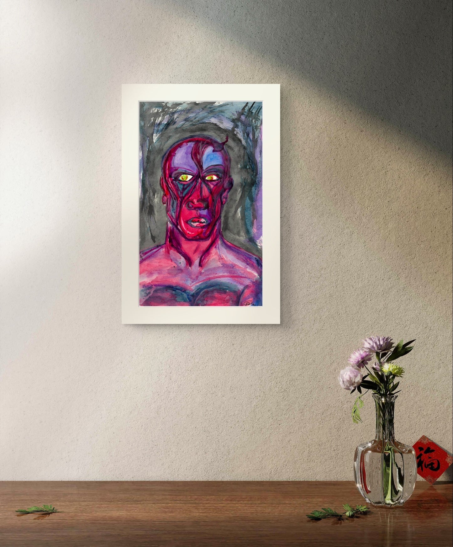 White bordered painting on grey wall above wooden table with flowers.