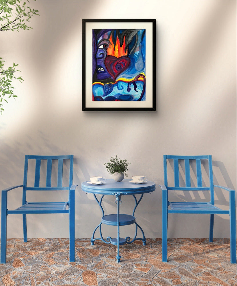 Black framed blue painting on white wall above blue table and chairs.
