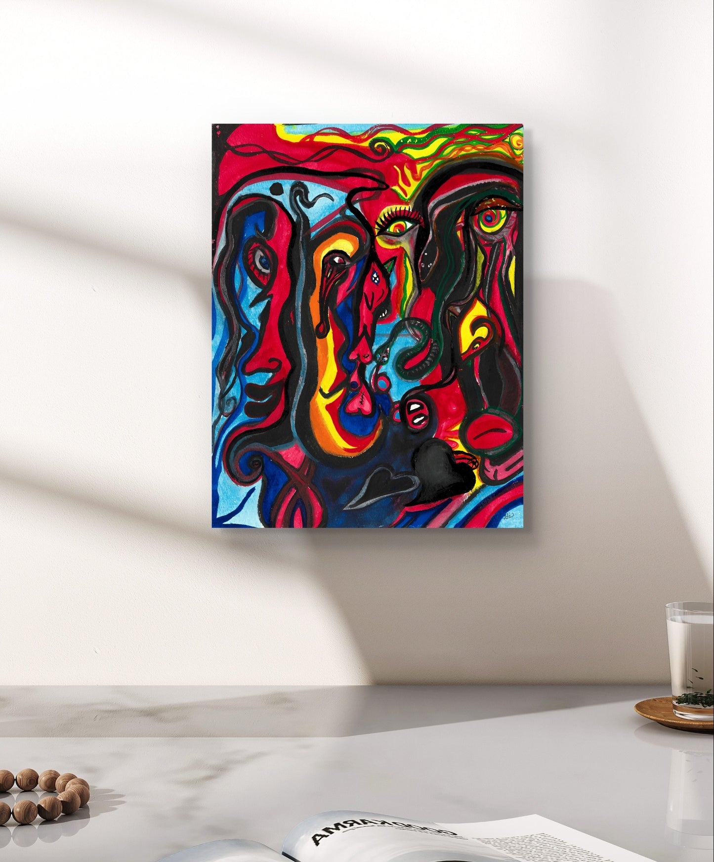 Colorful face painting on white wall above grey counter next to candle.