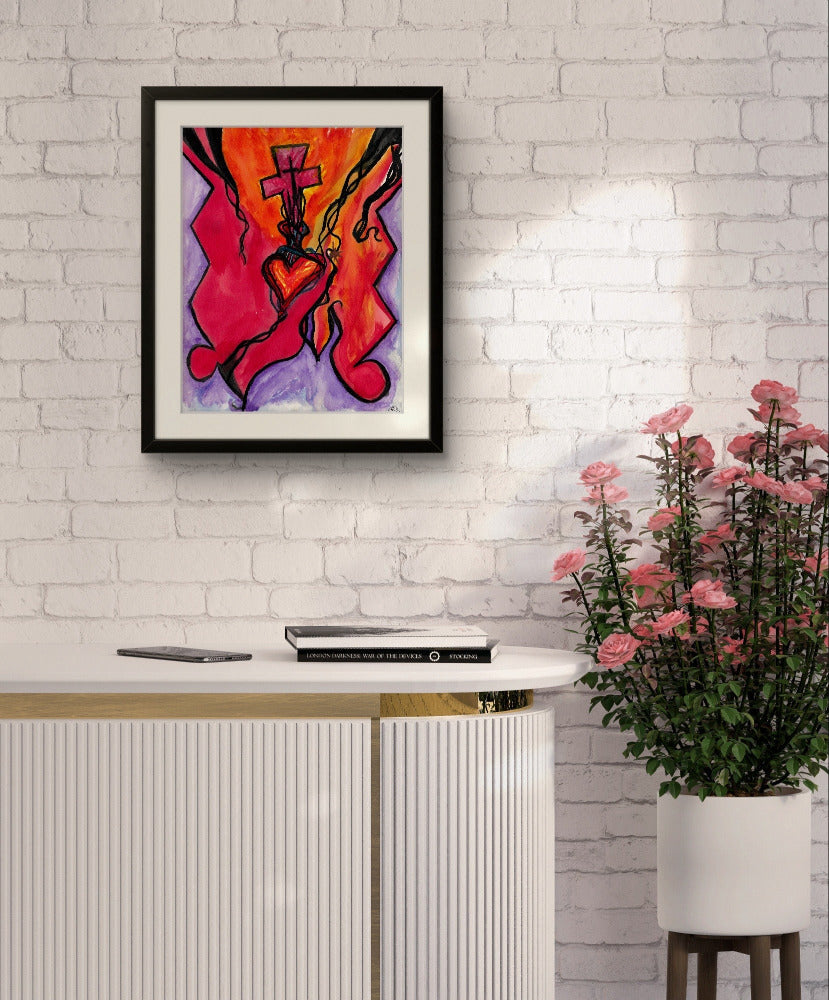 Black framed orange painting on white brick wall above table and pink flowers.