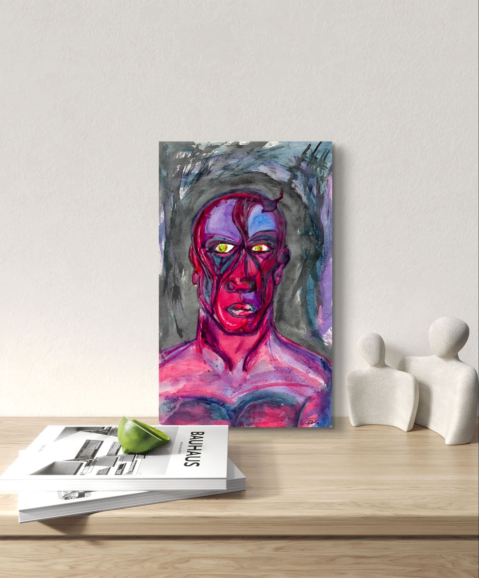 Painting of pink man on white wall above wooden table behind magazines.