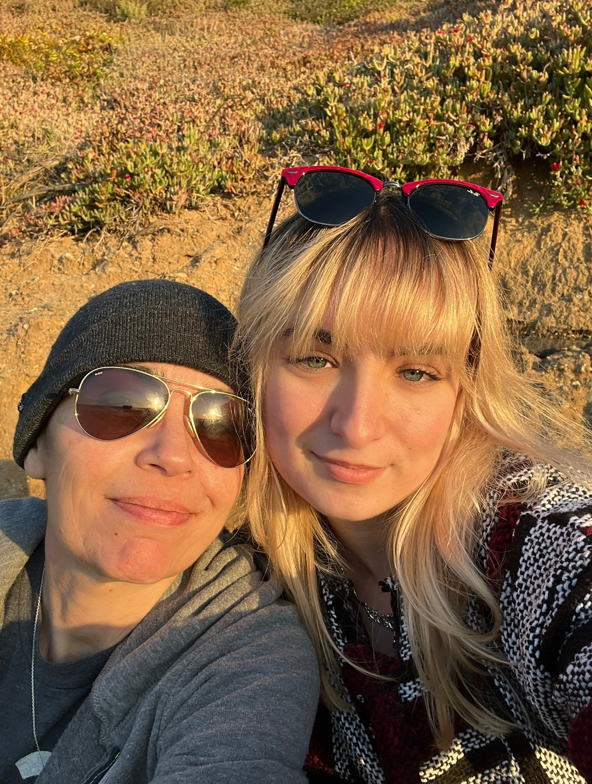 Two beautiful women on the beach smiling.